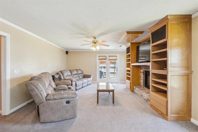 316 SE 6th St, Moore, OK 73160 - living room with crown molding, light colored carpet, a ceiling fan, a textured ceiling, and a brick fireplace