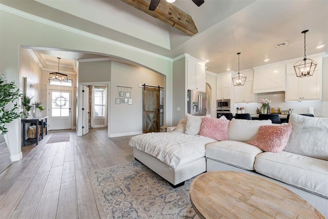 12004 SW 49th St, Mustang, OK 73064 - living room featuring arched walkways, a barn door, light wood-type flooring, crown molding, and baseboards