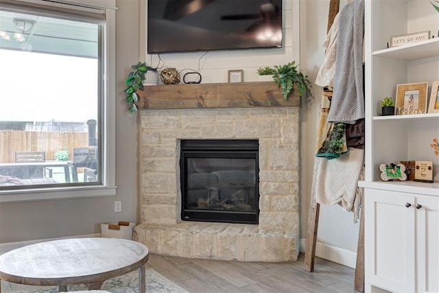12004 SW 49th St, Mustang, OK 73064 - living area with wood finished floors, a stone fireplace, and baseboards