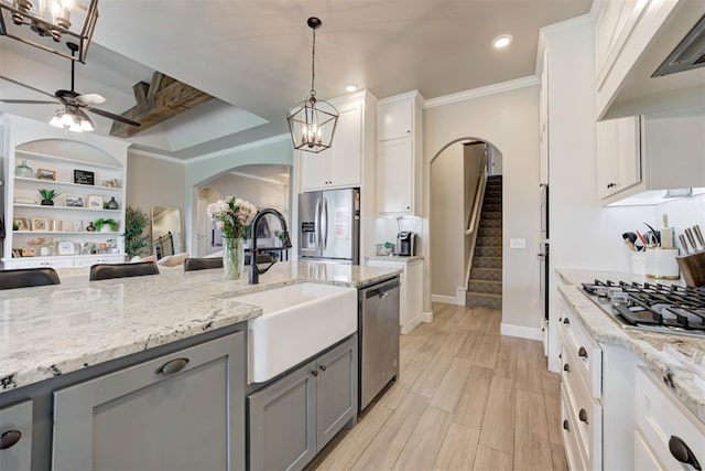 12004 SW 49th St, Mustang, OK 73064 - kitchen featuring a sink, appliances with stainless steel finishes, gray cabinetry, arched walkways, and under cabinet range hood