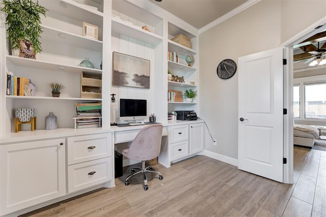 12004 SW 49th St, Mustang, OK 73064 - home office featuring light wood-style flooring, crown molding, a ceiling fan, built in desk, and baseboards