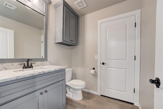 12004 SW 49th St, Mustang, OK 73064 - half bathroom featuring wood finished floors, vanity, baseboards, and toilet