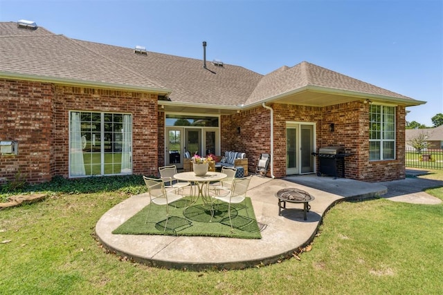 16523 Roserock Cir, Choctaw, OK 73020 - back of property featuring a patio, brick siding, roof with shingles, and an outdoor fire pit