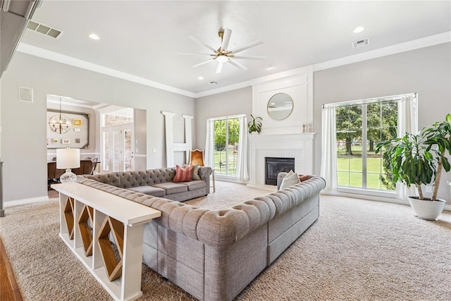 16523 Roserock Cir, Choctaw, OK 73020 - living room with a brick fireplace, ceiling fan, a chandelier, ornamental molding, and carpet flooring
