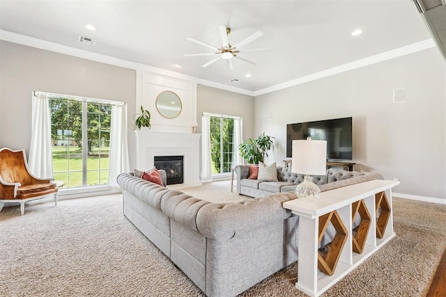 16523 Roserock Cir, Choctaw, OK 73020 - living room with ceiling fan, ornamental molding, a glass covered fireplace, recessed lighting, and carpet flooring