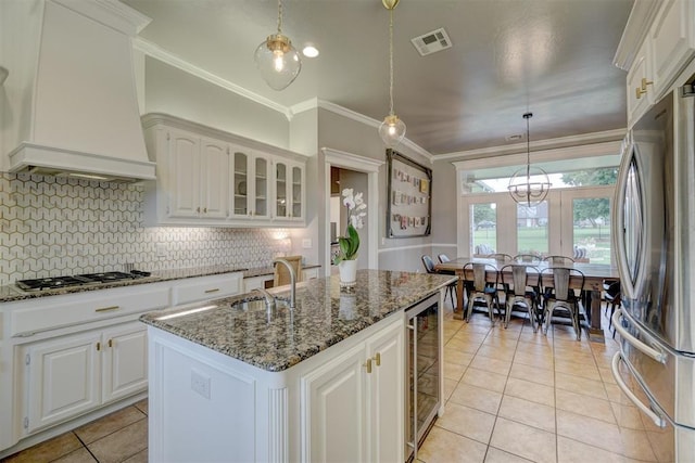 16523 Roserock Cir, Choctaw, OK 73020 - kitchen with appliances with stainless steel finishes, custom range hood, beverage cooler, ornamental molding, and light tile patterned floors