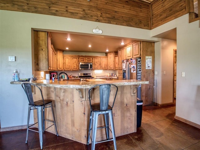 34325 E 1070th Rd, Mcloud, OK 74851 - kitchen with appliances with stainless steel finishes, a peninsula, baseboards, a kitchen bar, and recessed lighting