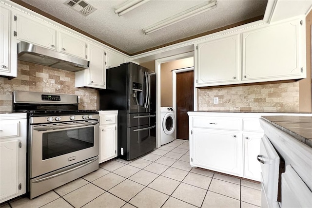 8409 Bigwood Dr, Oklahoma City, OK 73135 - kitchen with gas range, under cabinet range hood, washer / dryer, black fridge, and light tile patterned floors