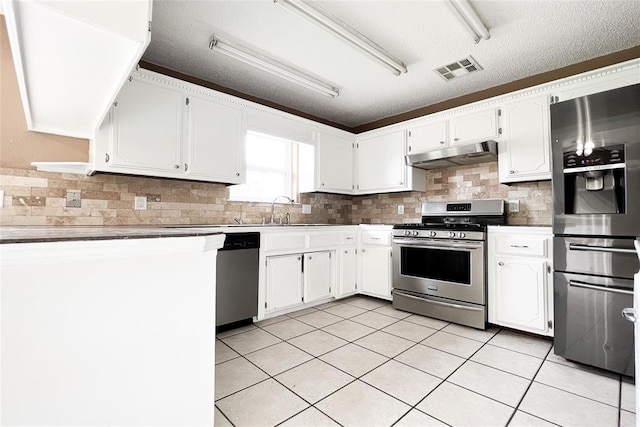 8409 Bigwood Dr, Oklahoma City, OK 73135 - kitchen with stainless steel appliances, under cabinet range hood, a sink, tasteful backsplash, and white cabinets