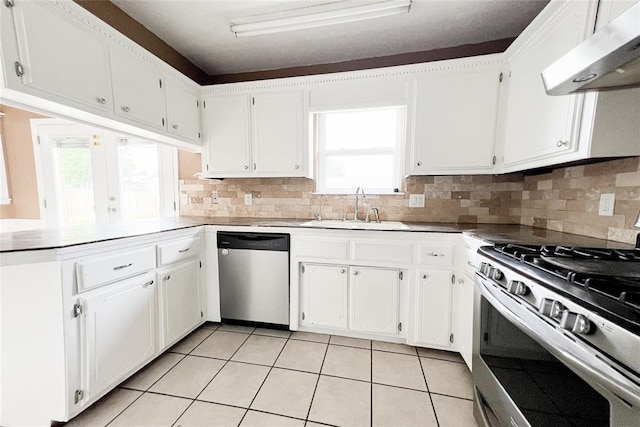 8409 Bigwood Dr, Oklahoma City, OK 73135 - kitchen featuring stainless steel appliances, under cabinet range hood, a sink, light tile patterned flooring, and healthy amount of natural light