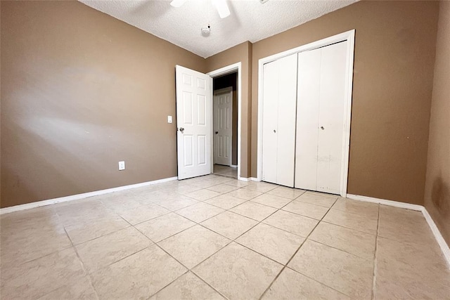 8409 Bigwood Dr, Oklahoma City, OK 73135 - unfurnished bedroom with baseboards, a textured ceiling, light tile patterned floors, a closet, and a ceiling fan
