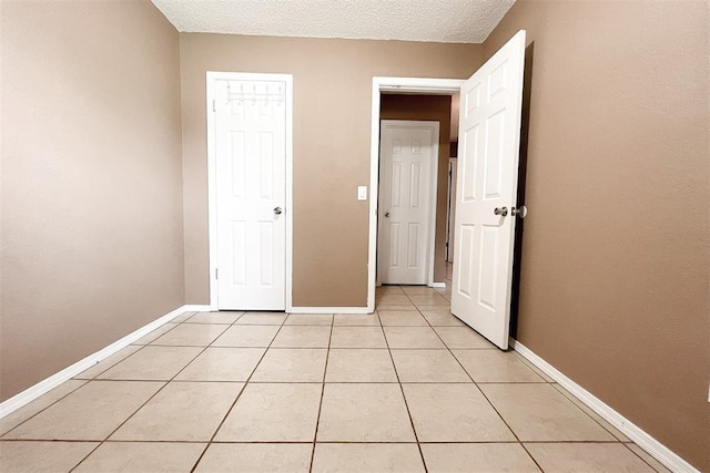 8409 Bigwood Dr, Oklahoma City, OK 73135 - unfurnished bedroom with light tile patterned floors, baseboards, and a textured ceiling