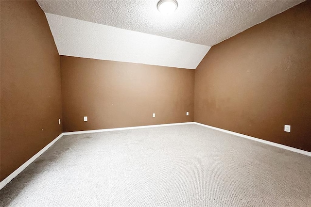 8409 Bigwood Dr, Oklahoma City, OK 73135 - additional living space with carpet floors, lofted ceiling, a textured ceiling, and baseboards