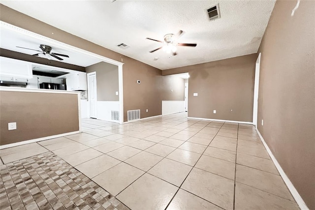 8409 Bigwood Dr, Oklahoma City, OK 73135 - unfurnished living room with a ceiling fan, light tile patterned floors, baseboards, and a textured ceiling