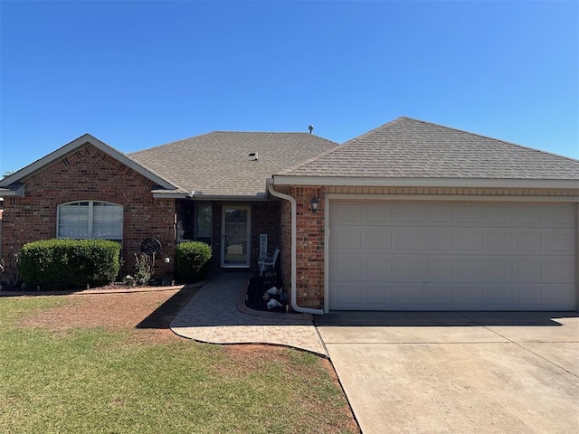 520 E Juniper Ln, Mustang, OK 73064 - ranch-style house with roof with shingles, a garage, brick siding, and concrete driveway