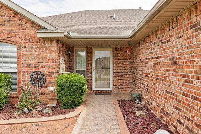 520 E Juniper Ln, Mustang, OK 73064 - property entrance featuring a shingled roof and brick siding