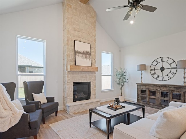 7909 NW 162nd St, Edmond, OK 73013 - living room featuring high vaulted ceiling, wood finished floors, a fireplace, a ceiling fan, and baseboards