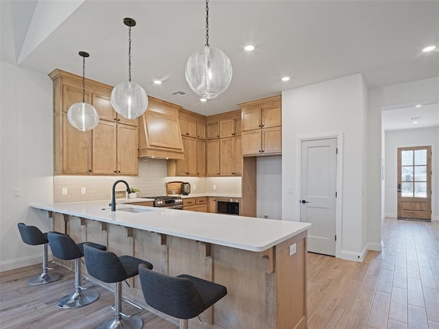 7909 NW 162nd St, Edmond, OK 73013 - kitchen with a sink, premium range hood, a peninsula, baseboards, and recessed lighting