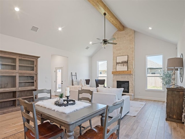 7909 NW 162nd St, Edmond, OK 73013 - dining area with beam ceiling, a ceiling fan, light wood finished floors, high vaulted ceiling, and a fireplace