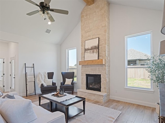 7909 NW 162nd St, Edmond, OK 73013 - living area featuring high vaulted ceiling, a stone fireplace, baseboards, light wood-type flooring, and ceiling fan