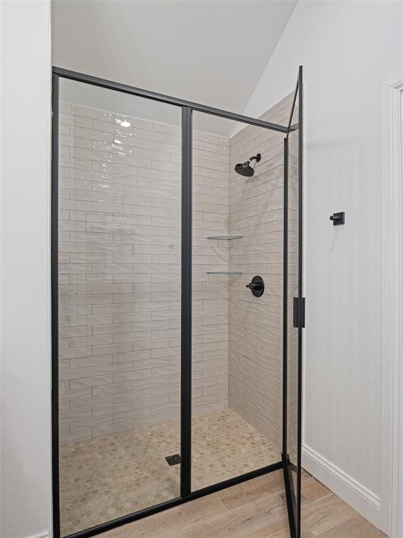 7909 NW 162nd St, Edmond, OK 73013 - bathroom with a stall shower, wood finished floors, and lofted ceiling