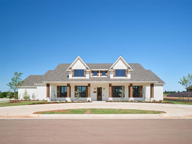 7909 NW 162nd St, Edmond, OK 73013 - view of front of property with curved driveway, a shingled roof, and covered porch