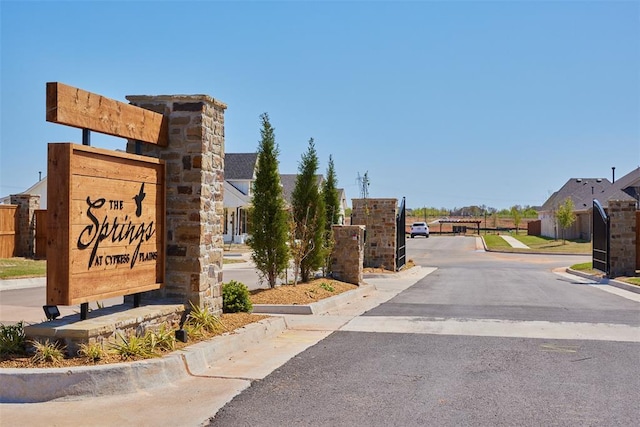 7909 NW 162nd St, Edmond, OK 73013 - view of asphalt road with curbs and a gated entry
