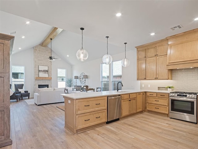 7909 NW 162nd St, Edmond, OK 73013 - kitchen featuring stainless steel appliances, light brown cabinets, ceiling fan, a peninsula, and beamed ceiling