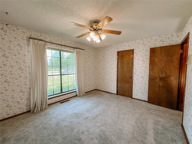 715 N Max, Hinton, OK 73047 - unfurnished bedroom featuring wallpapered walls, a textured ceiling, a ceiling fan, and carpet flooring