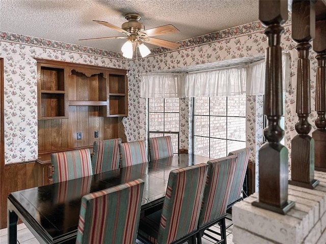 715 N Max, Hinton, OK 73047 - dining space featuring wallpapered walls, a ceiling fan, a textured ceiling, a wainscoted wall, and wood walls