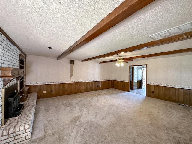 715 N Max, Hinton, OK 73047 - unfurnished living room featuring a textured ceiling, wood walls, ceiling fan, beam ceiling, and a wainscoted wall