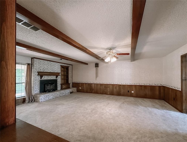 715 N Max, Hinton, OK 73047 - unfurnished living room with a textured ceiling, ceiling fan, wooden walls, wainscoting, and carpet