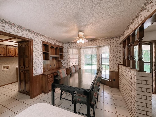 715 N Max, Hinton, OK 73047 - dining room with wallpapered walls, a ceiling fan, a wainscoted wall, a textured ceiling, and light tile patterned floors
