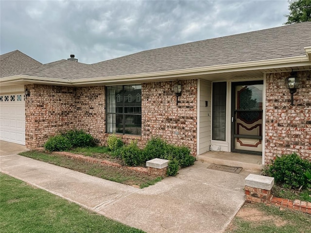 715 N Max, Hinton, OK 73047 - entrance to property featuring a shingled roof, an attached garage, and brick siding