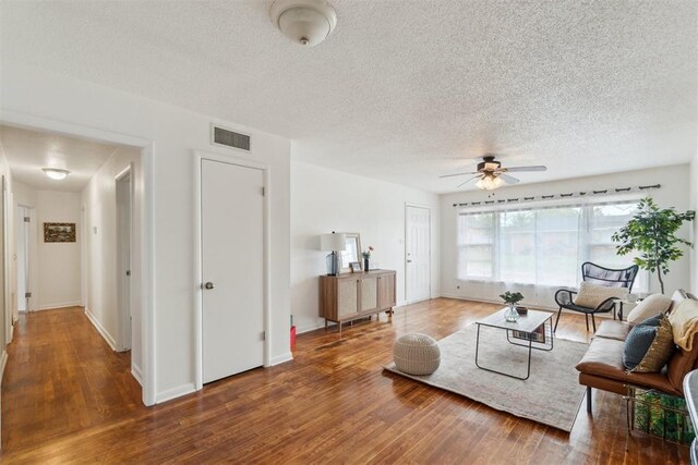 3831 NW Bell Ave, Lawton, OK 73505 - living room featuring a ceiling fan, wood finished floors, a textured ceiling, and baseboards