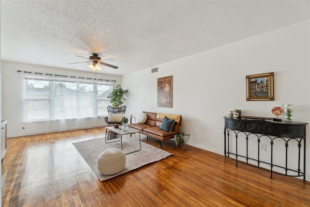 3831 NW Bell Ave, Lawton, OK 73505 - living room with ceiling fan, a textured ceiling, wood finished floors, and baseboards