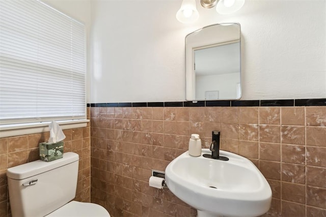 3831 NW Bell Ave, Lawton, OK 73505 - half bathroom with tile walls, a sink, toilet, and wainscoting