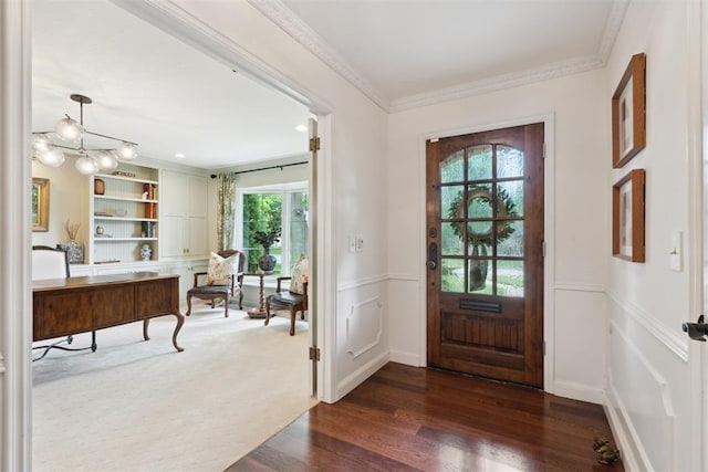1201 Westchester Dr, Oklahoma City, OK 73114 - entrance foyer with healthy amount of natural light, dark wood finished floors, ornamental molding, a wainscoted wall, and a chandelier