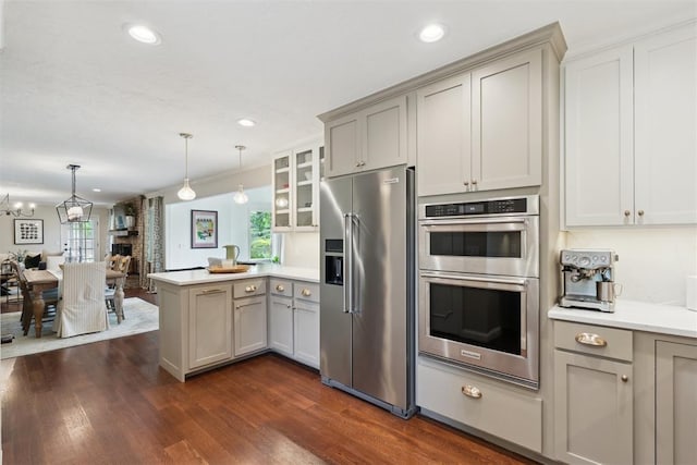 1201 Westchester Dr, Oklahoma City, OK 73114 - kitchen with appliances with stainless steel finishes, a peninsula, gray cabinetry, dark wood-style floors, and light countertops