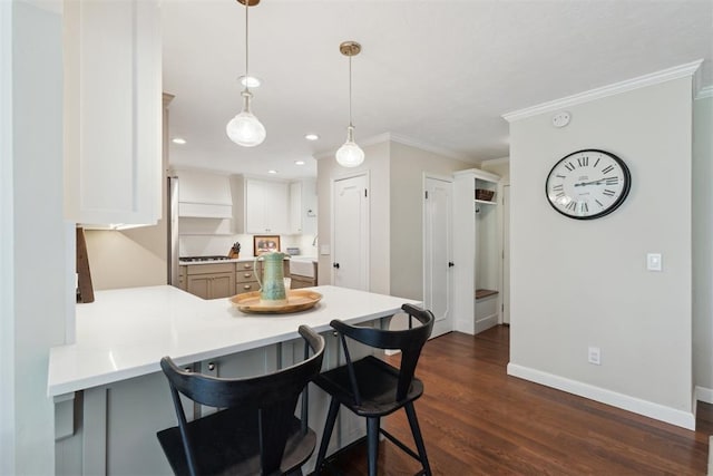1201 Westchester Dr, Oklahoma City, OK 73114 - kitchen with a peninsula, baseboards, a breakfast bar, light countertops, and ornamental molding