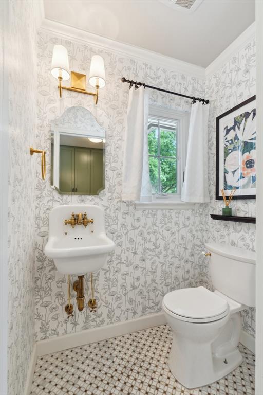 1201 Westchester Dr, Oklahoma City, OK 73114 - half bath with crown molding, baseboards, toilet, and a sink