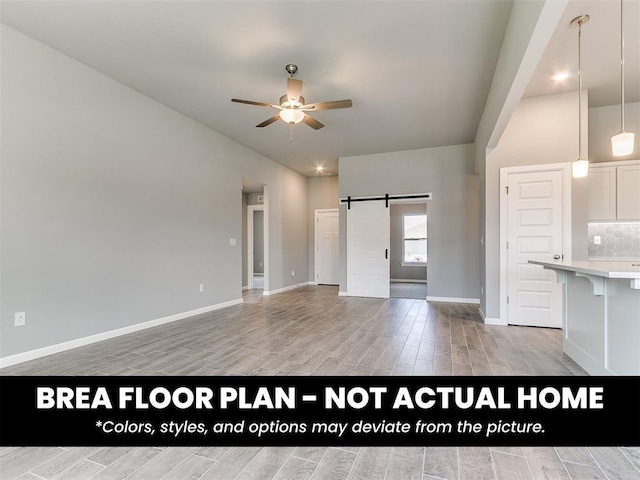 1100 Redwood Creek Dr, Yukon, OK 73099 - unfurnished living room with light wood-style flooring, a barn door, ceiling fan, and baseboards