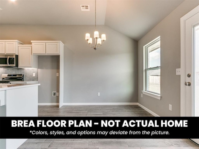 1100 Redwood Creek Dr, Yukon, OK 73099 - kitchen with stainless steel appliances, lofted ceiling, decorative light fixtures, tasteful backsplash, and white cabinetry