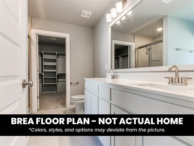 1100 Redwood Creek Dr, Yukon, OK 73099 - full bathroom featuring a spacious closet, a shower stall, double vanity, tile patterned floors, and toilet