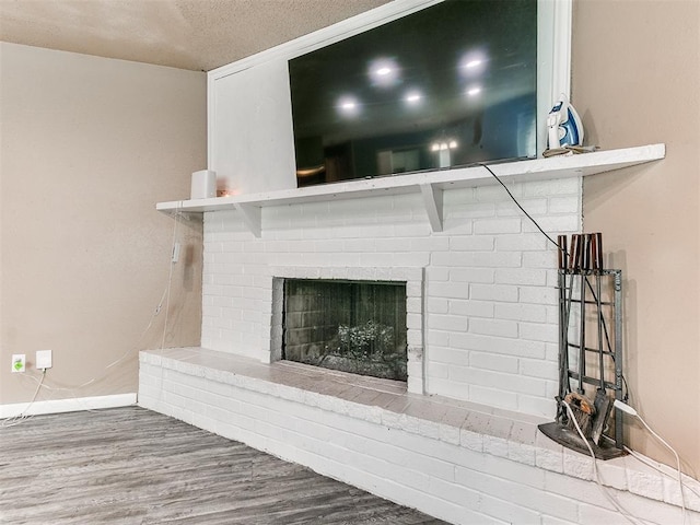 216 N English Dr, Moore, OK 73160 - detailed view of wood finished floors, baseboards, a fireplace, and a textured ceiling