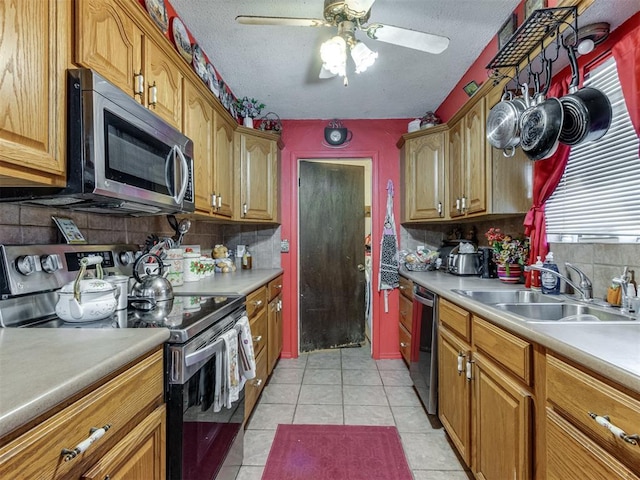 2904 N Shannon Ave, Bethany, OK 73008 - kitchen with stainless steel appliances, a sink, tasteful backsplash, a ceiling fan, and a textured ceiling