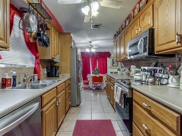 2904 N Shannon Ave, Bethany, OK 73008 - kitchen with appliances with stainless steel finishes, ceiling fan, a sink, decorative backsplash, and a textured ceiling