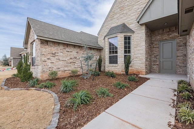 9120 SW 34th St, Oklahoma City, OK 73179 - doorway to property with a shingled roof and stone siding