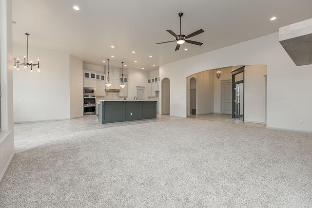 9120 SW 34th St, Oklahoma City, OK 73179 - unfurnished living room with a chandelier, arched walkways, a ceiling fan, recessed lighting, and baseboards