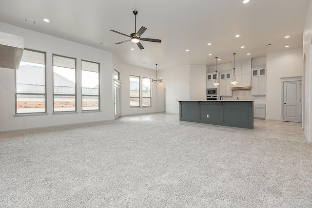 9120 SW 34th St, Oklahoma City, OK 73179 - unfurnished living room with recessed lighting, a ceiling fan, a chandelier, and light carpet